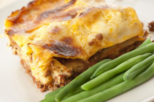Tasty Lasagna on Plate with Green String Beans