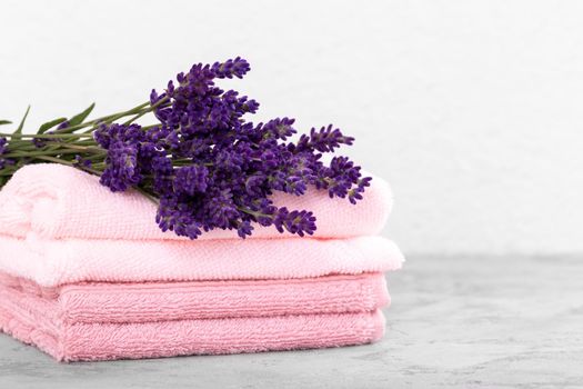Stack of pink cotton towels and bouquet of lavender 