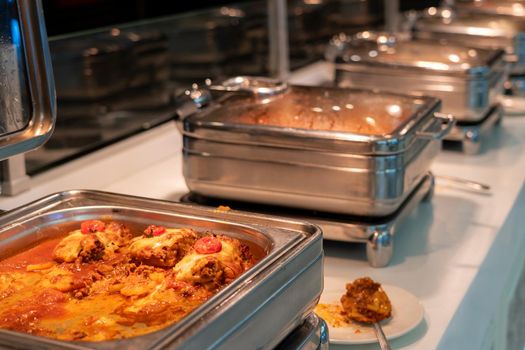 Countertop food warmer with meat dish in hotel buffet restaurant