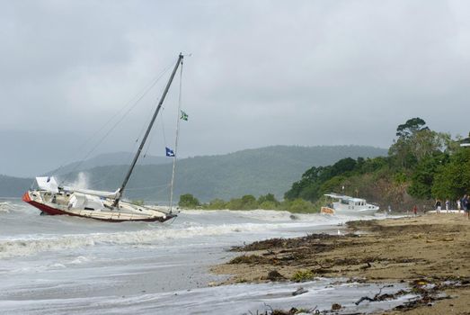 Shipwrecked yacht lies aground near the shore
