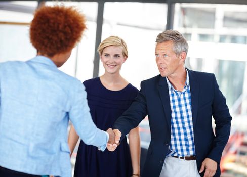 Adding a talented new member to their team. A mature business manager shaking hands with an employee.