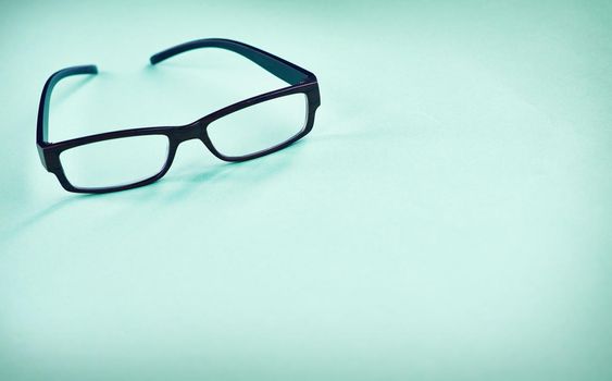All the better to see you with. Studio shot of a pair of glasses on a green background.