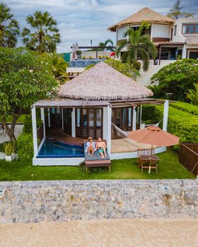 Couple in luxury villa enjoying in the plunge pool looking out over ocean and beach