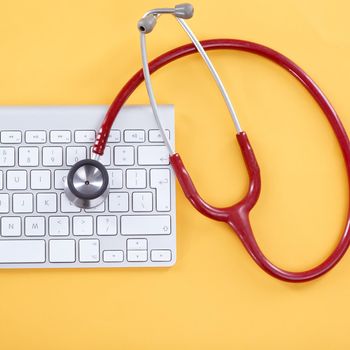 Care for your computer. Concept shot of a keyboard and stethoscope on a yellow background.
