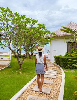 Women in luxury villa walking to the looking out over ocean and beach