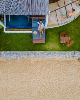 Couple in luxury villa enjoying in the plunge pool looking out over ocean and beach