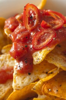 Topping of hot chili salsa on corn tortilla chips
