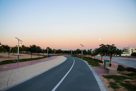 Jogging and cycling tracks in Al Warqa park, Dubai, UAE in the evening. Lamp post powered by solar panels can be seen in the picture. Outdoors