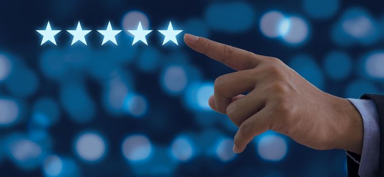 Hand of businessman touching five stars symbol to increase rating on background