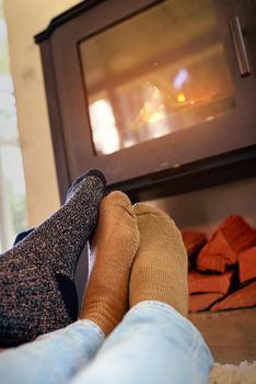 Winter is a time to gather golden moments. a couple sitting by the fireplace.