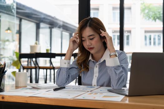 Business asian woman get stressed and headache while having a problem at work in office