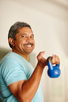 Working those biceps. a mature man lifting dumbbells.