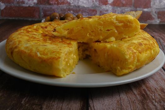 typical spanish potato omelet with a portion cut on top of it