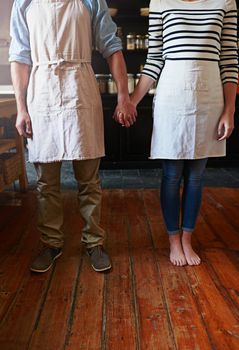 Keep calm and put your apron on. a couple wearing aprons in the kitchen.