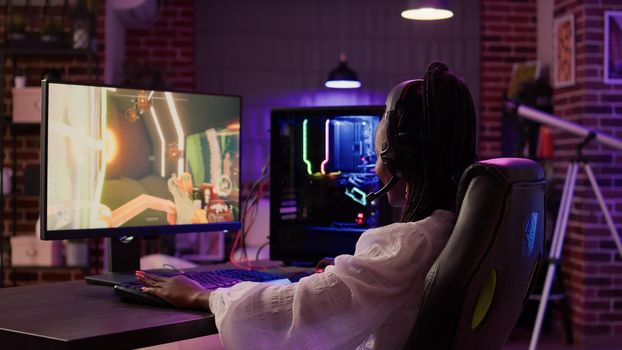 African american gamer girl using pc gaming setup aving a good time playing multiplayer online action game