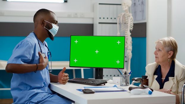 Male nurse and woman with impairment analyzing greenscreen display