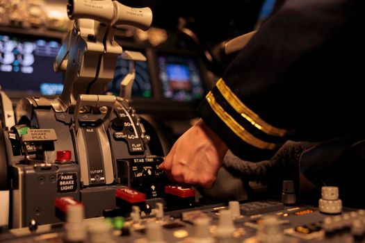 Female copilot pushing dashboard buttons in plane cockpit