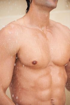 Dripping with masculinity. a handsome young man enjoying a refreshing shower.