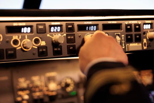 Captain pushing buttons to fix altitude level on control panel command