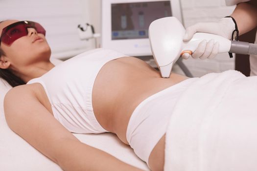 Young woman getting laser hair removal at beauty clinic