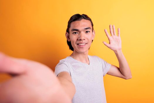 Man talking on video call, holding smartphone, waving hi