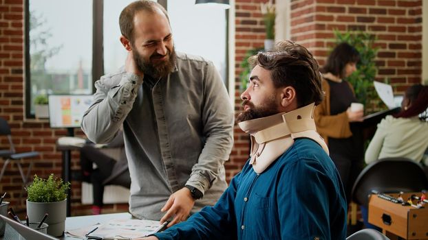 Business man in pain wearing cervical neck foam at office job