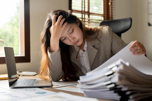 Asian business woman stressed office worker overloaded with paperwork.