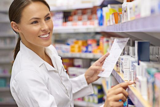 Finding the best treatment possible. an attractive young pharmacist collecting a prescription in an aisle.