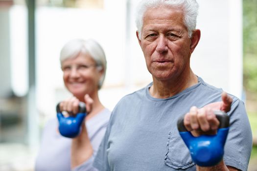 Strength training for seniors. a senior couple training with light weights outdoors.
