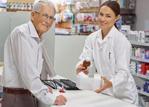 My clients always leave informed. Portrait of a young pharmacist helping an elderly customer at the prescription counter.