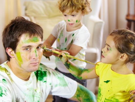 This is what happens when Moms away for the weekend. a dad being painted by his children.