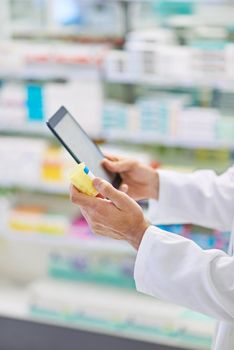 Lets see what the internet says. A pharmacist working on a digital tablet.