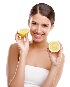 Add some freshness to your skin. Studio portrait of a young woman holding up two halves of a lemon.