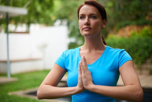 Peaceful focus. a young woman in a meditative yoga pose outdoors.