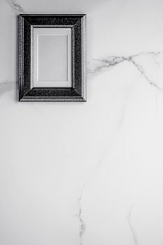 Black photo frame on marble, flatlay