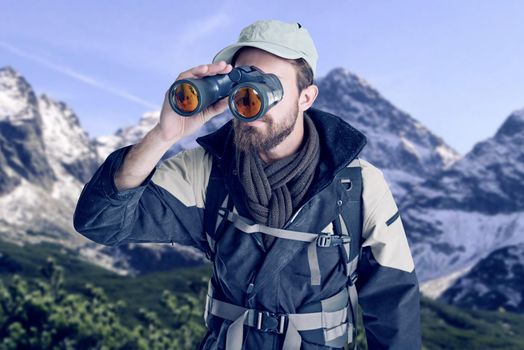 Following his navigational instincts. hiker looking through binoculars in a remote landscape.