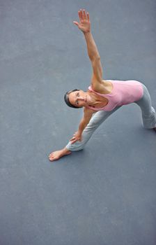 Perfecting the triangle pose. a mature woman doing the extended triangle yoga pose outdoors.