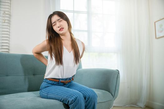 Asian woman holding her lower back feeling painful waist hurt massage