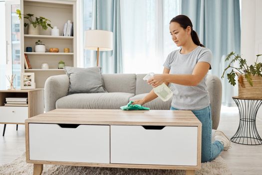 Cleaning, hygiene and house task with a woman spring cleaning, sanitize living room furniture. Young female wipe and dust, enjoying fresh routine housework in a modern, germ free living space