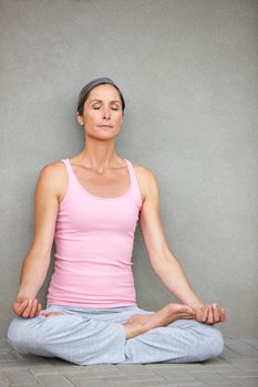Your thoughts are like the clouds...an attractive mature woman practicing yoga in the lotus position.