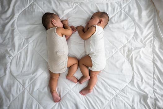 Happy childhood, Sleeping newborn identical boy twins on the bed on bedroom, Asian two adorable twin babies boy, family people infant