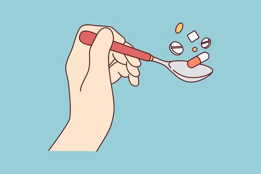 Hand holding spoon of pills
