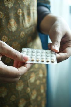 female hand golding birth control pills