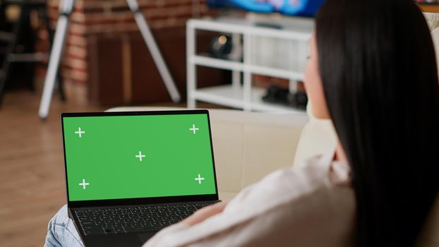 Woman having laptop with green screen chroma key template display