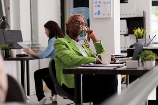 Employee having remote conversation with colleagues on landline phone