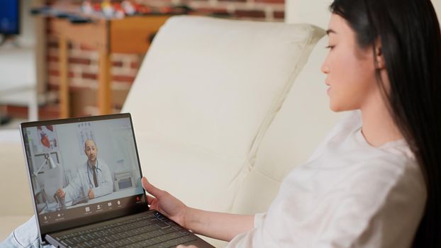 Person talking with doctor on virtual videoconference online call while working from home