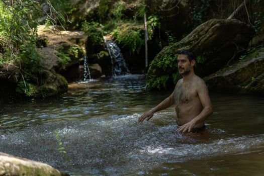 man in the river splashing water with his hands