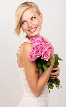 These flowers are so pink. An attractive young woman with a bunch of pink roses.