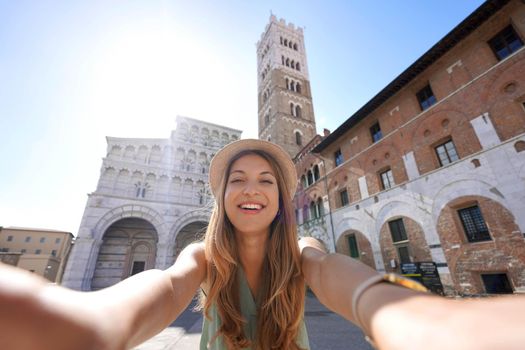 Beautiful traveler girl takes selfie photo in Lucca, Tuscany, Italy