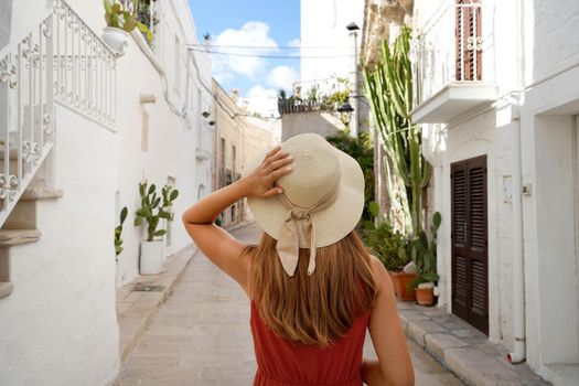Traveler girl walks through the alleys in a picturesque town in Apulia region, Italy 